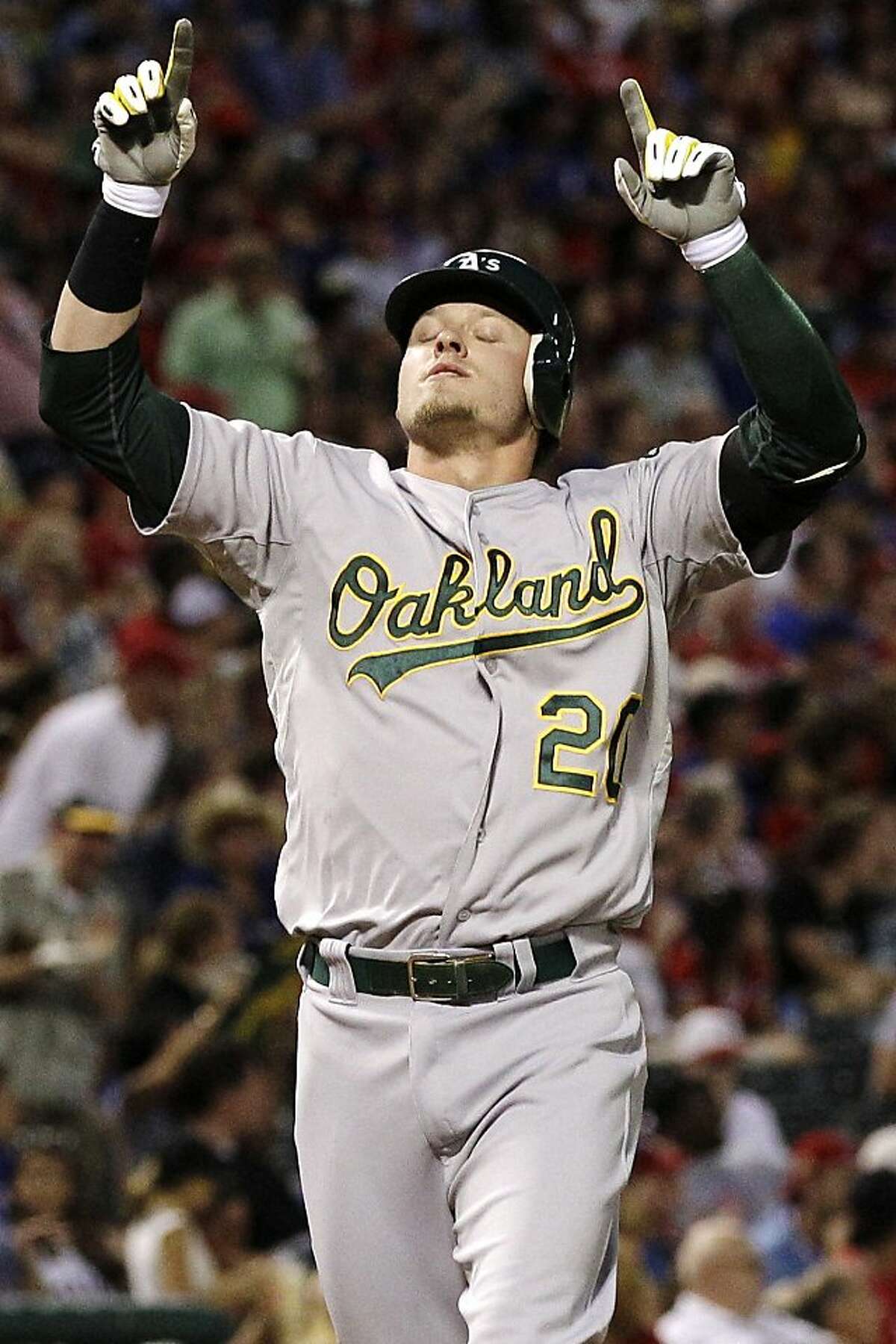 Oakland Athletics' Josh Donaldson points skyward as he approaches the plate following his two-run home run in the second inning of a baseball game against the Texas Rangers, Monday, Sept. 24, 2012, in Arlington, Texas. Brandon Moss also scored on the hit. (AP Photo/Tony Gutierrez)