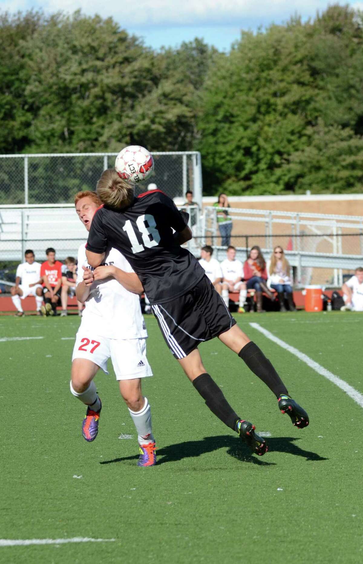New Canaan's Eben Jones (18) goes up for a header against Warde's Alex Landau (27) during the boys soccer game at Tetreau/Davis field at Fairfield Warde High School on Monday, Sept. 24, 2012.