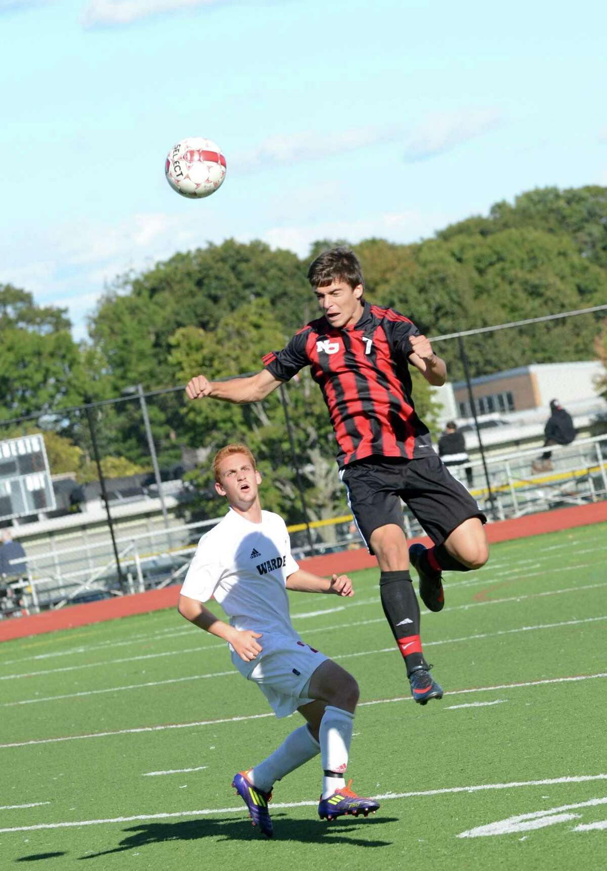 New Canaan's Robert Valente (7) goes up for a header as Warde's Alex Landau (27) defends during the boys soccer game at Tetreau/Davis field at Fairfield Warde High School on Monday, Sept. 24, 2012.