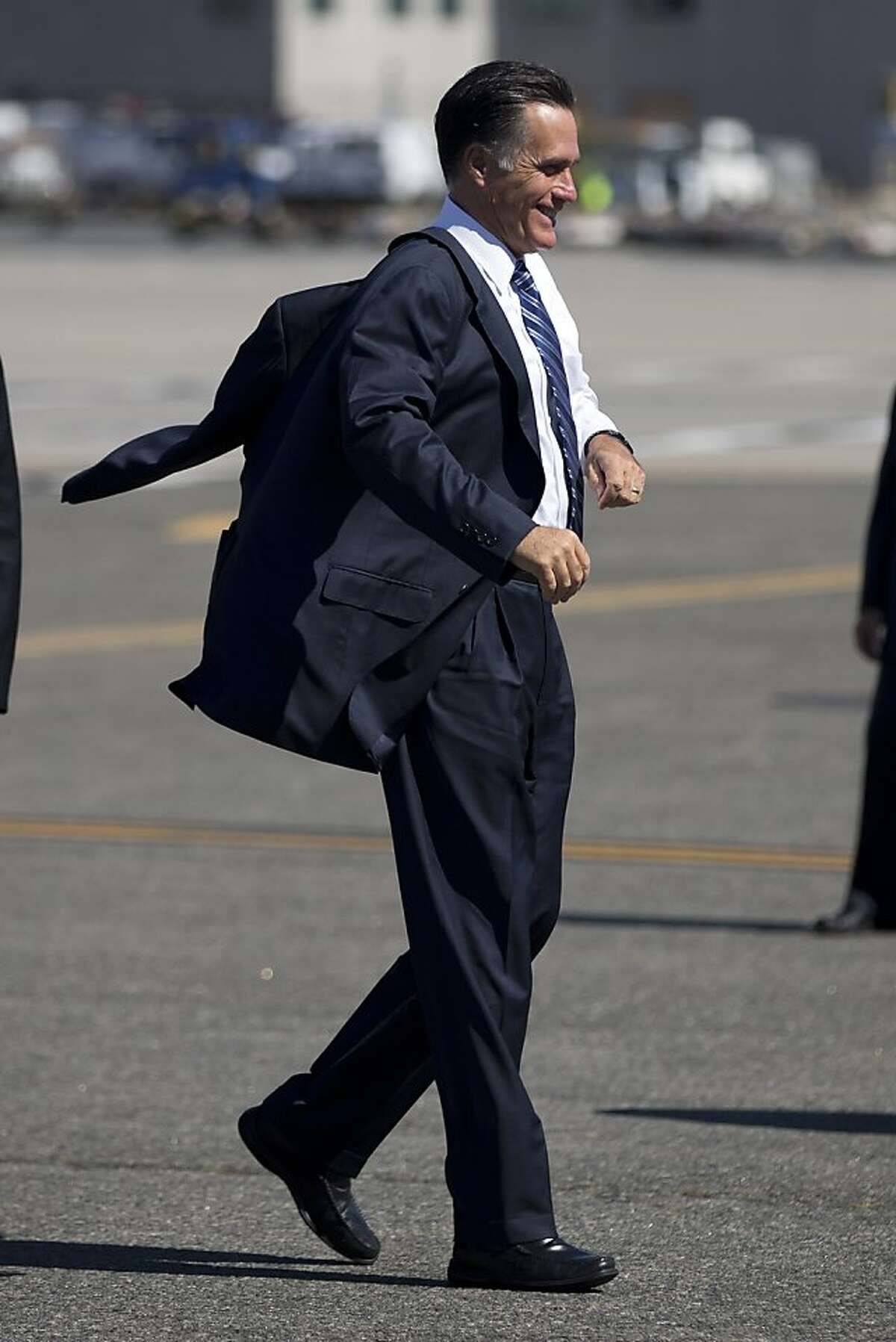 Republican presidential candidate, former Massachusetts Gov. Mitt Romney puts on a jacket as he boards a flight for a campaign stop in Dayton, Ohio, Tuesday, Sept. 25, 2012, in Newark, N.J. (AP Photo/ Evan Vucci)
