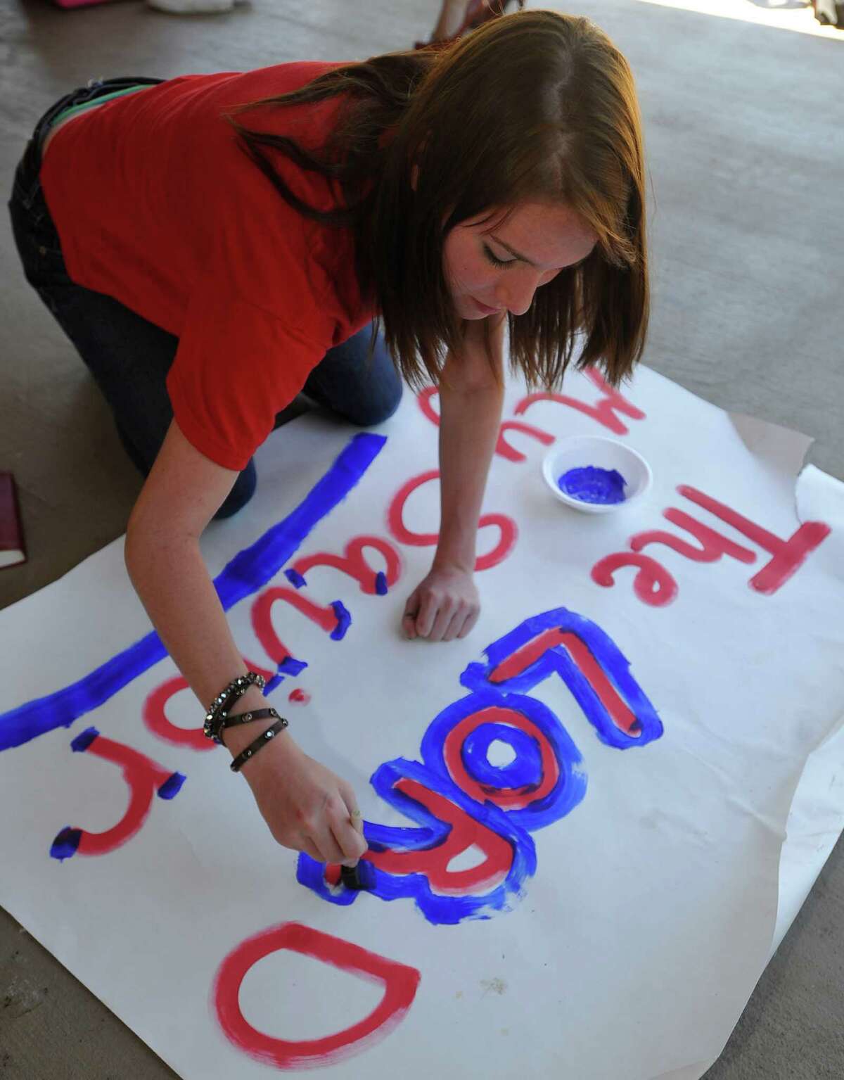 Ashton Lawrence, a cheerleader, enhances her latest piece of work on the patio. Kountze cheerleaders, friends and supportive parents who are standing up for their kids and their beliefs, were making signs and painting car windows Wednesday afternoon that will be seen around Kountze in support of the cheerleaders who were told they could not put scripture on their football signs. Each game this season, the Kountze cheerleaders have made Christian-themed run-through signs for the football players. The signs, which featured scripture verses, went viral and have now been stopped by the school district's leaders who were told by a group the signs were offensive and against the separation of church and state. Dave Ryan/The Enterprise