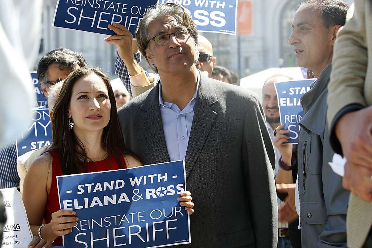 Eliana Lopez (in red) and her husband Ross Mirkarimi (right) listen to people rallying in his support in front of the steps of city hall in San Francisco, Calif., on Monday, September 17, 2012.