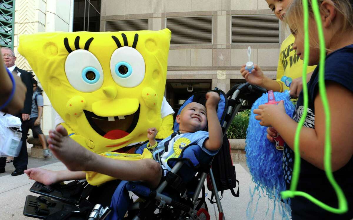 Alan Sanders, 4, is greeted by the cartoon character "Sponge Bob Square Pants" and children as he arrives at the Weston Centre in downtown San Antonio to receive his wish from the Make-A-Wish program on Thursday, Sept. 27, 2012. Alan, who has cancer, wanted to ride the elevator in San Antonio's tallest building and press all the buttons to all the floors. People that work in the building greeting him with streamers and cheers each time the elevator door opened.