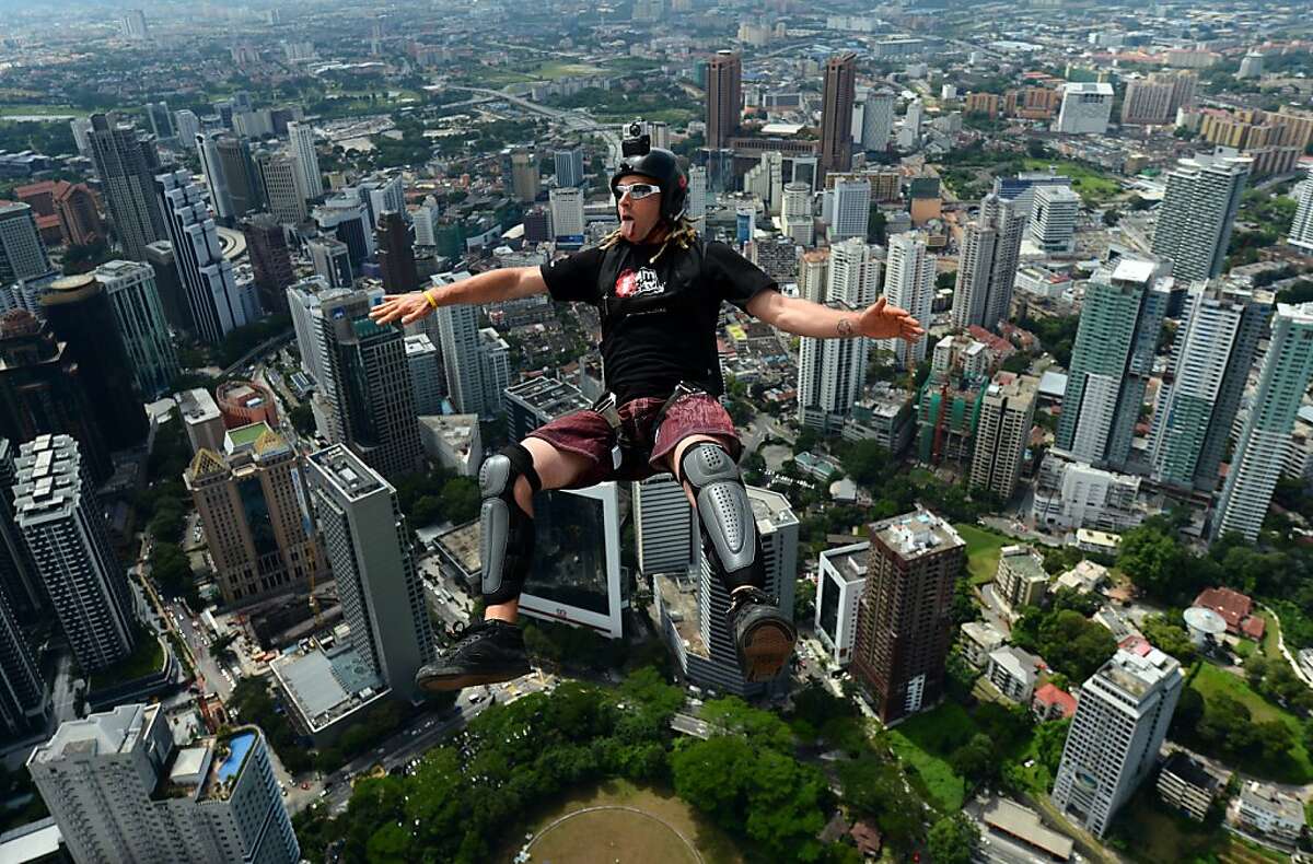 Adrenaline junkie: Base jumper Paul Morton of New Zealand jumps backward off the 421-meter (1,381-foot) Kuala Lumpur Tower during the four-day International Tower Jump. He has only seconds to open his parachute before he lands.