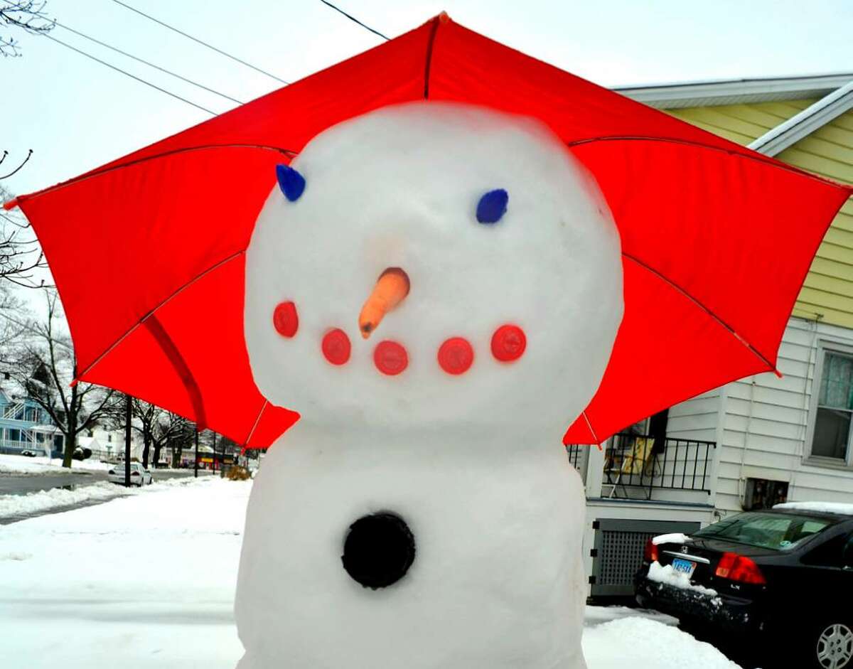 A snowman uses an umbrella to protect himself from the rain on Meadow Avenue, in Danbury, on Wendesday, Dec.9,2009.