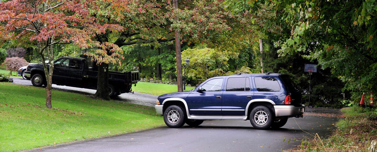 A neighbor's car blocks the end of Donnelly Drive in New Fairfield to prevent the news media from accessing the back of the Giuliano and Scocozza homes Friday, Sept. 28, 2012.