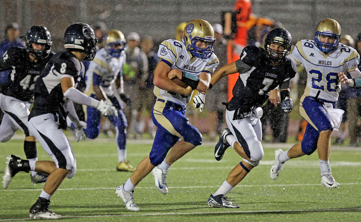 Mules quarterback Kalen Brockwell protects a slippery ball as he runs in the first half as Champion hosts Alamo Heights at Boerne Stadium on September 28, 2012.