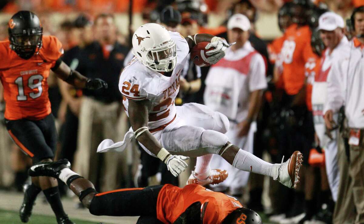 Texas running back Joe Bergeron (24) tries to get past Oklahoma State safety Daytawion Lowe, bottom, during the fourth quarter of an NCAA college football game in Stillwater, Okla., Saturday, Sept. 29, 2012. Texas won 41-36. AP Photo/Sue Ogrocki)