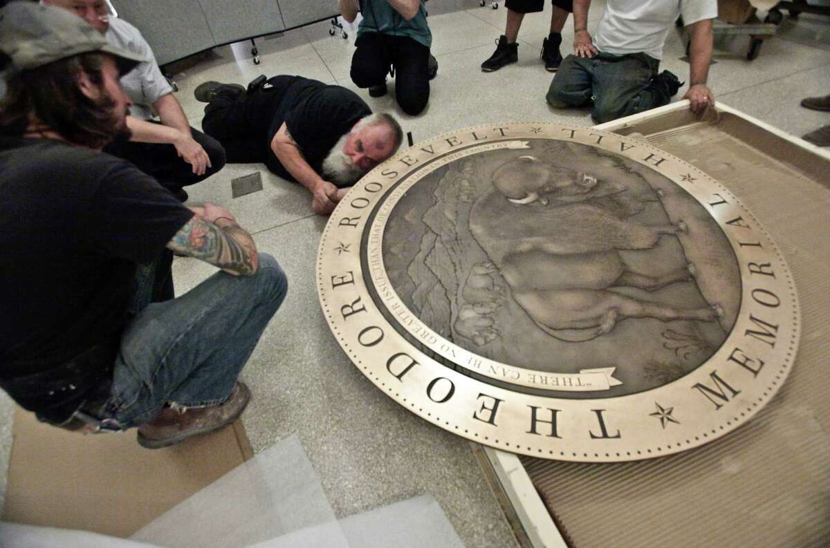In this Thursday, Sept. 27, 2012 photo, workers prepare a floor medallion for the Theodore Roosevelt Memorial at the American Museum of Natural History in New York. The AMNH is reopening the two-story Theodore Roosevelt Memorial after a three-year, $42.1 million restoration project.