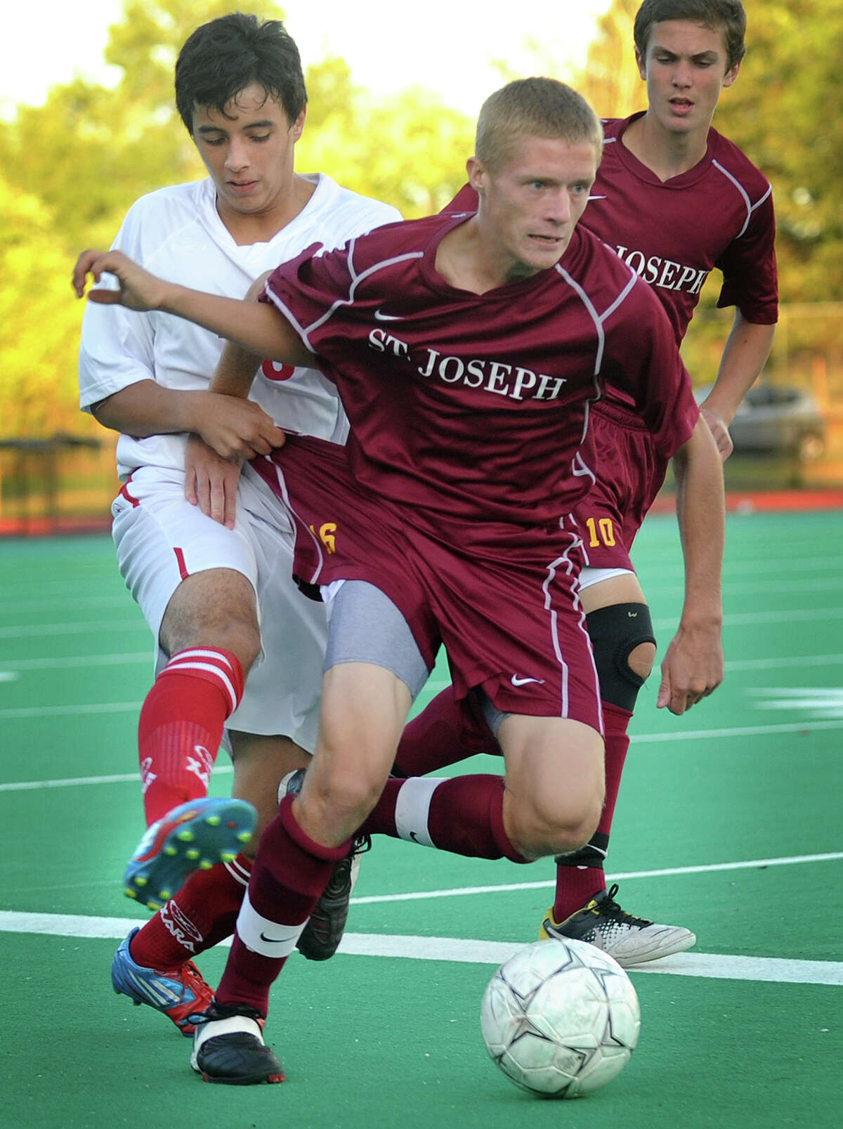 Central's Juan Arango, left, grabs hold of the uniform of St. Joseph's Sean Martino as he pursues the ball during their matchup at Central High School in Bridgeport on Monday, October 1, 2012.