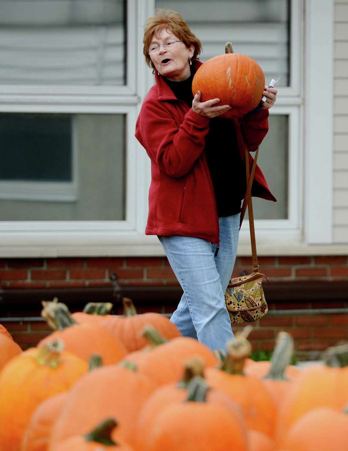 Helen Mooney of Albany carries her pumpkin to the check out at the McKownville Methodist Church in Albany, N.Y. October 1, 2012. Profits from the sale of the pumpkins support the mission scholarships at the church. (Skip Dickstein/Times Union)