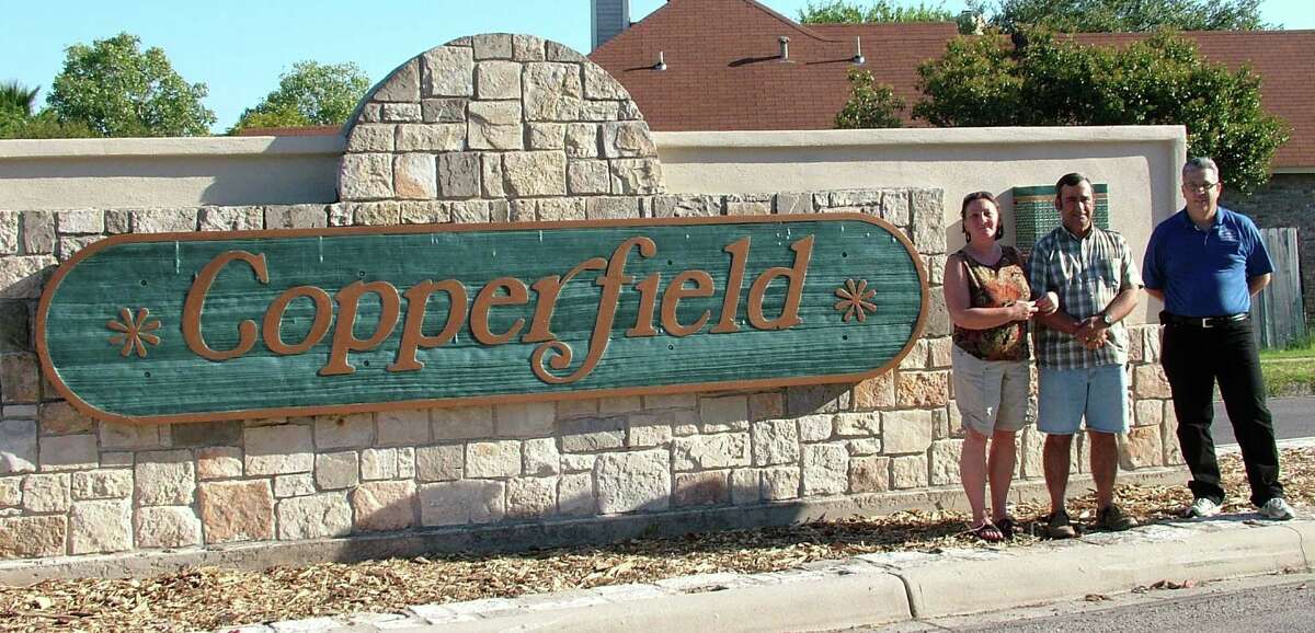 Volunteers spruce up subdivision's entry sign