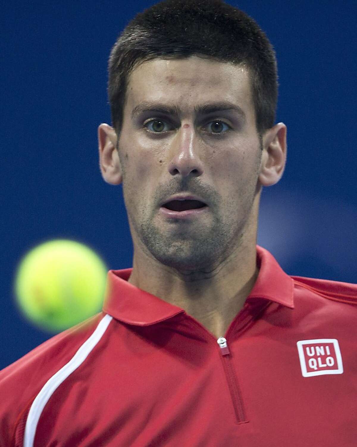 Serbia's Novak Djokovic stares looks at a ball while playing against Michael Berrer of Germany in their men's singles match of the China Open tennis tournament in Beijing Tuesday, Oct. 2, 2012. Djokovic defeated Berrer 6-1, 6-7, 6-2. (AP Photo/Andy Wong)