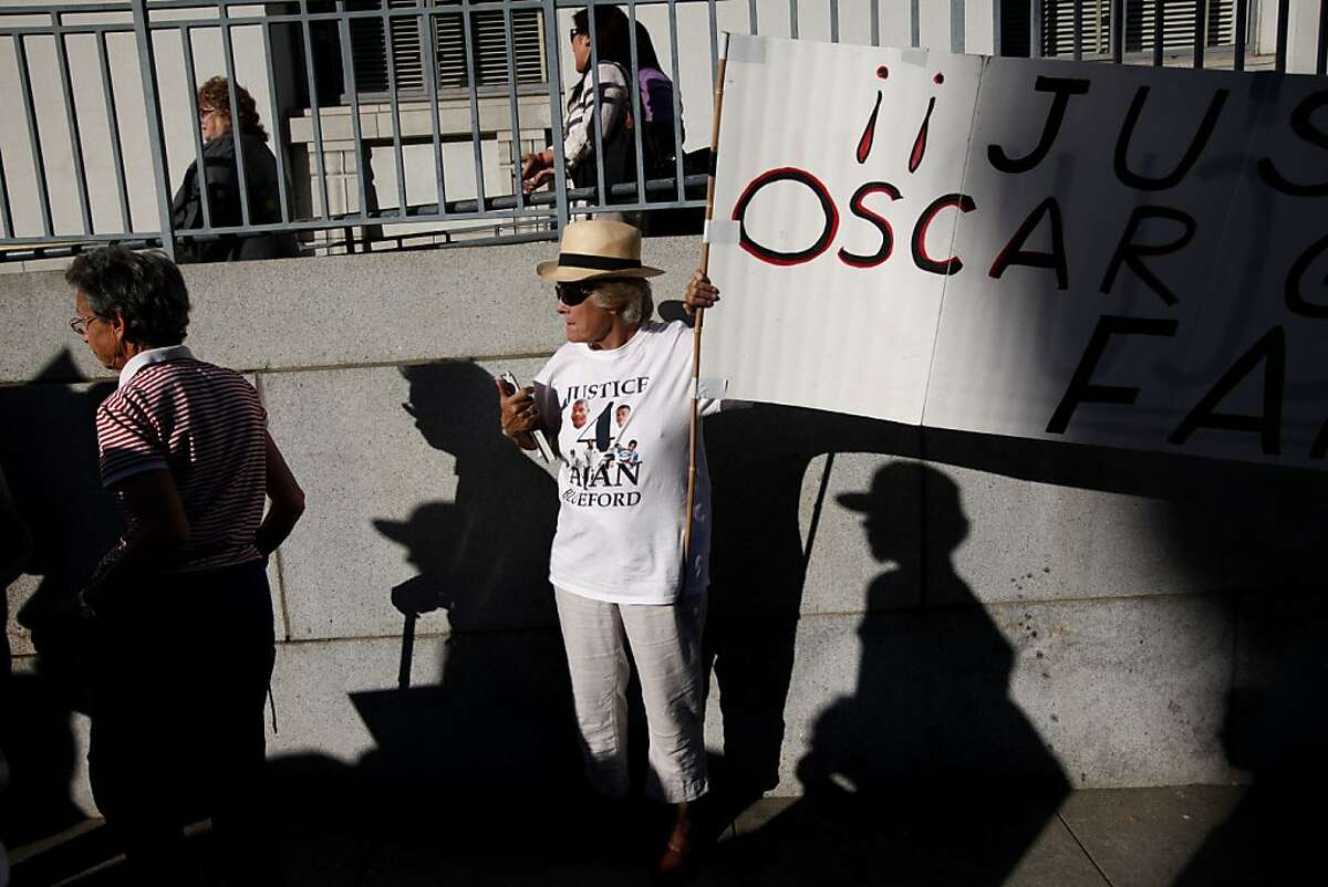 Kathy Colliau, of Walnut Creek, carries a sign during a march to City Hall to protest at the city council meeting in Oakland, Calif., Tuesday, October 2, 2012. The family of Alan Blueford, who was killed in May by a police officer, are demanding the police finish their investigation of Blueford's shooting.