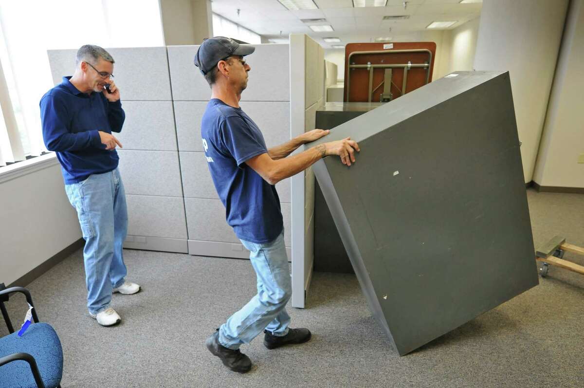 Troy Bureau of Code Enforcement Principal Code Inspector Dave Sheeran, left, guides Dave Clark of Schapp Moving Systems, right, as he moves a file cabinet into their new space in the Hedley Park building, as the first phase of moving City Hall into their new space began, on Wednesday Oct. 3, 2012 in Troy, NY. (Philip Kamrass / Times Union)