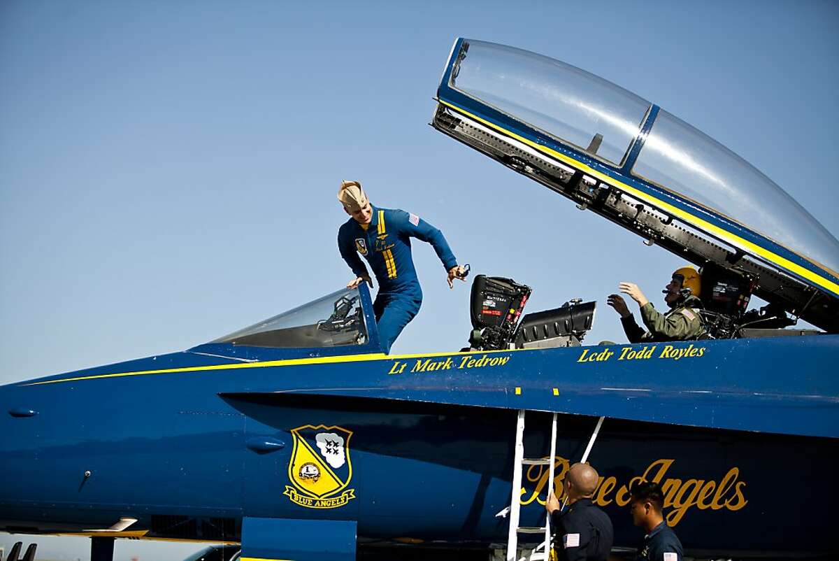 Navy Blue Angel Lt. Mark Tedrow, center, exits the cockpit of an F-18 Hornet on the tarmac at SFO after giving UC Berkeley astronomy professor Alex Filippenko, in back, a member of both teams whose research led to the 2011 Nobel Prize in physics, the ride of his life as part of their Key Influencer Program.