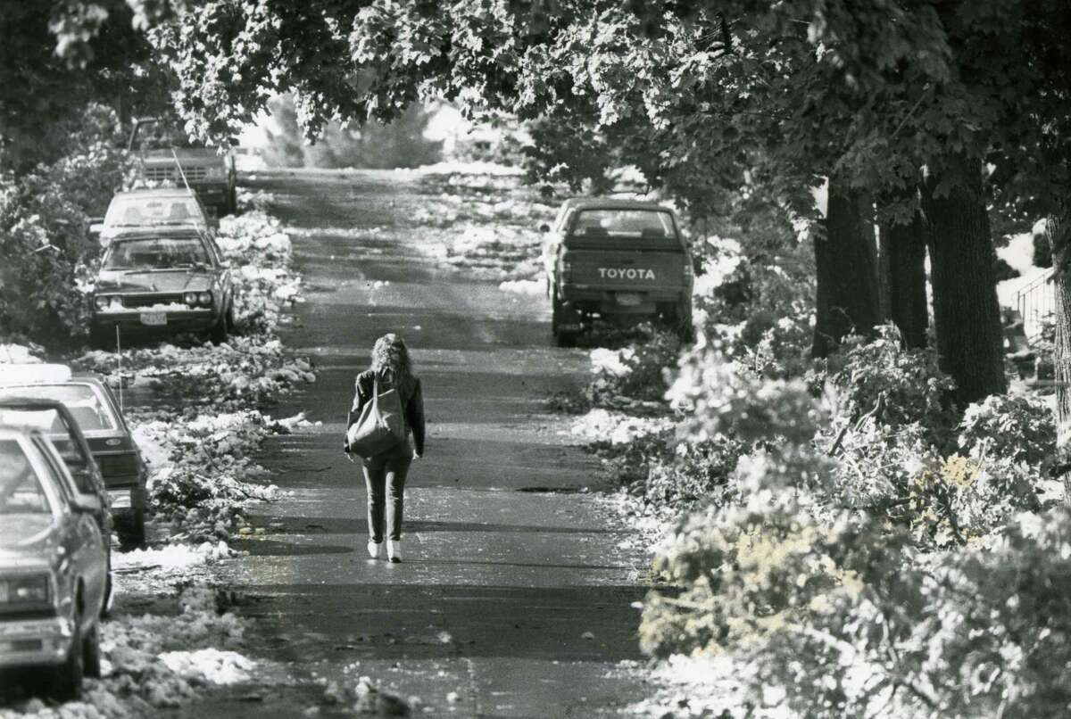 A young woman walks down an unusually heavy tree lined Pinewood Street, on October 5, 1987, as a result of the storm in Albany, N.Y. (Times Union / Skip Dickstein archive)