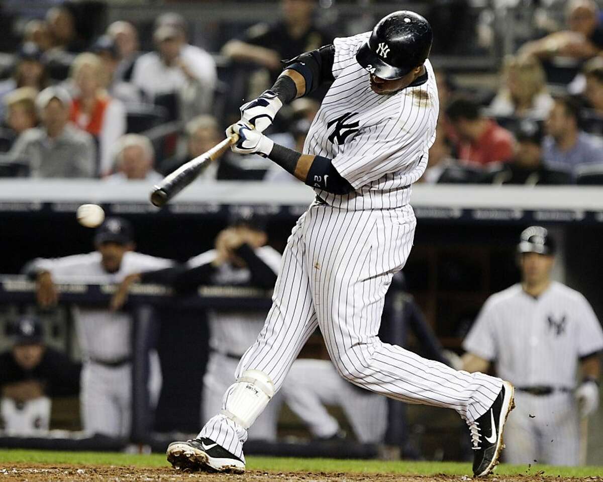 New York Yankees' Robinson Cano hits a two-RBI single during the sixth inning of a baseball game against the Boston Red Sox, Wednesday, Oct. 3, 2012, in New York. Russell Martin and Ichiro Suzuki scored on the hit. (AP Photo/Frank Franklin II)