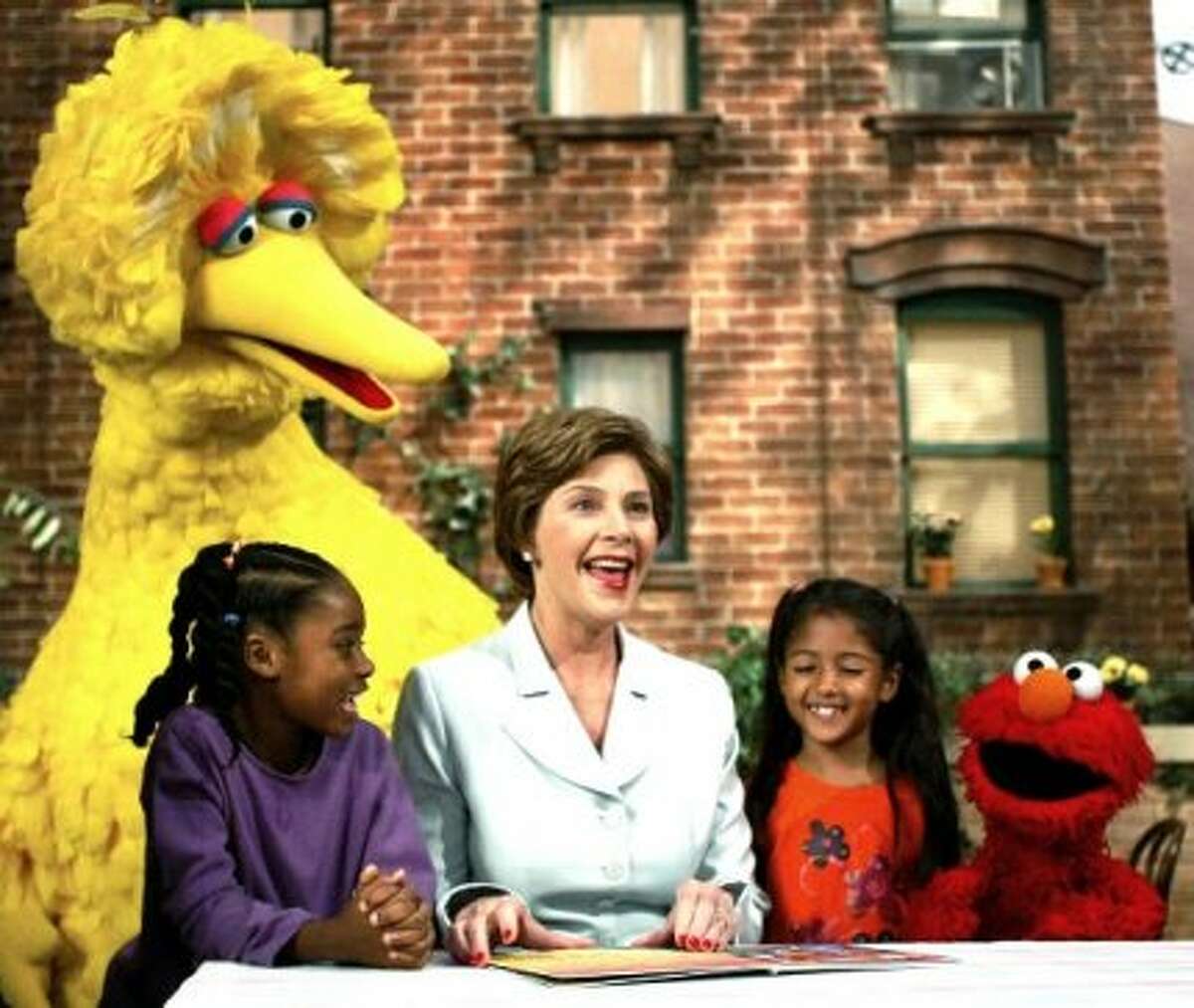 In 2002, Former First Lady Laura Bush, center, read a book to Sydney Martinez, Big Bird, Sienna Jerries and Elmo. (AP Photo)