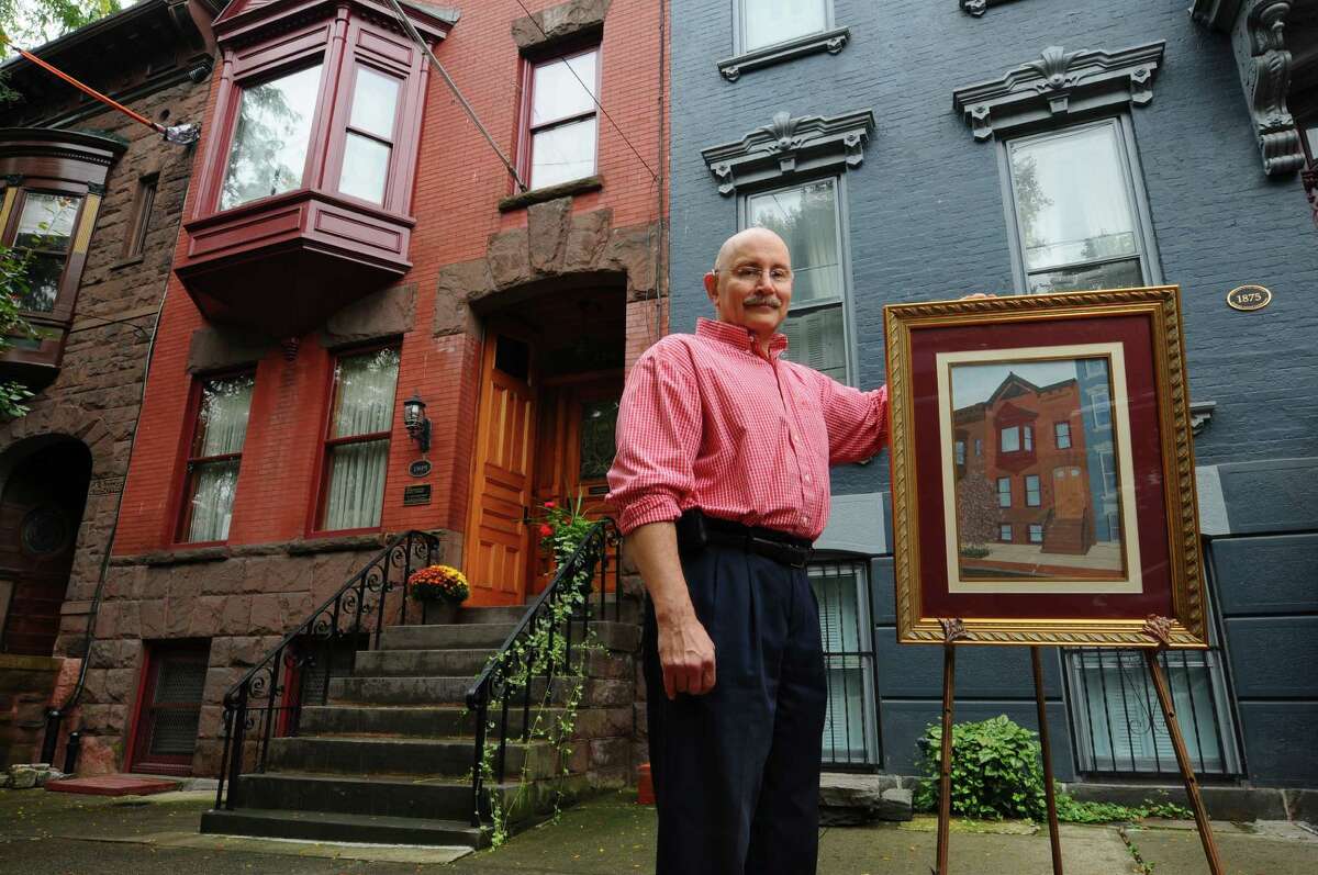 Tony Mariano stands in front of his Lancaster Street home, with a framed portrait of the house, on Wednesday Oct. 3, 2012 in Albany, NY. (Philip Kamrass / Times Union)