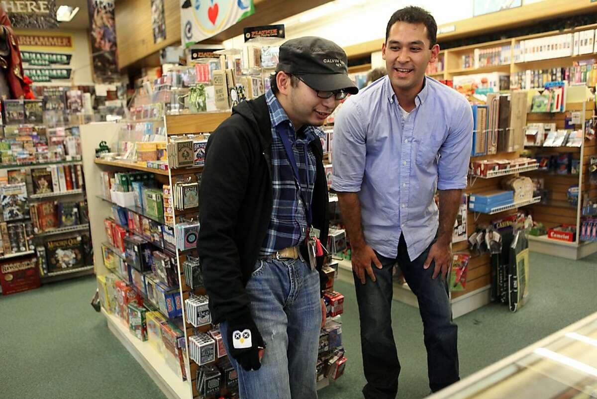 Guido Abenes (left) checking out cards at the game store with his social mentor Ben Nomura-Weingrow in Berkeley, Calif., on Thursday, September 27, 2012.