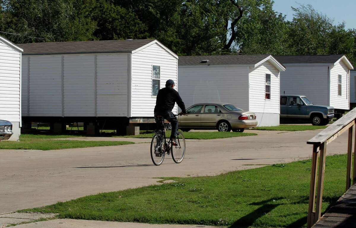 A resident rides a bicycle on the grounds of Hand Up Ministries in Oklahoma City, Wednesday, Oct. 3, 2012. Hand Up Ministries is a non profit faith-based organization that offers help to men and women coming out of the prison system to re-enter society. The grounds currently house 150 sex offenders and 7 other felons. (AP Photo/Sue Ogrocki)