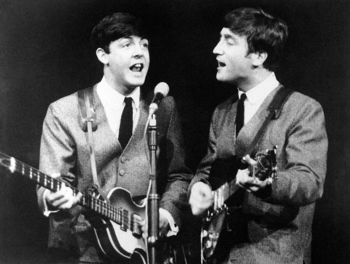 Paul McCartney, left, and John Lennon, two members of the Beatles pop group during a concert in London, on Nov. 11, 1963. (AP Photo/N)