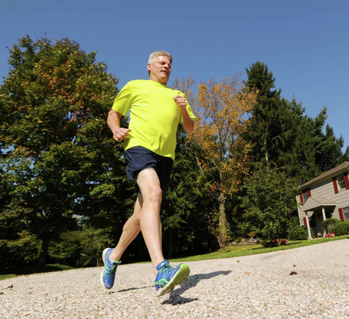 John McCarthy runs on the driveway of his Round Hill Road in Greenwich, Friday afternoon, Oct. 5, 2012. McCarthy will be running in the ING New York City Marathon Nov. 4 to raise money for the Hole in the Wall Gang Camp, a camp for kids with cancer and serious blood diseases that his son, Jeremiah, a cancer survivor, attended.