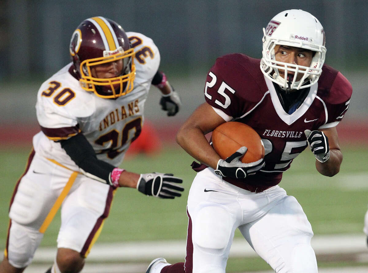 Floresville's Hector Villegas (25) takes a look back after slipping past Harlandale's Brandon Garza (30) in high school football in Floresville, Texas on Friday, Oct. 5, 2012.