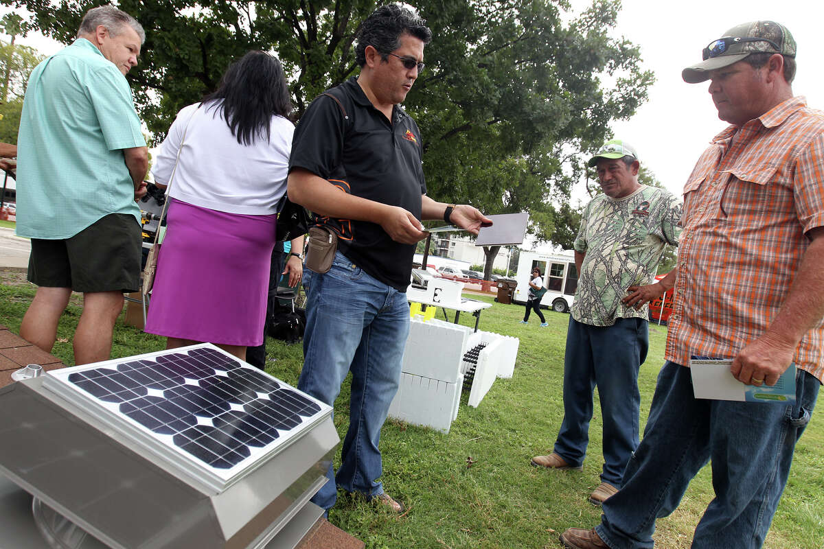 Raciel Juarez, CEO of Texas Green Solar & Wind Solutions, explains solar technology to Oscar Moreno and Ernie Ayala during Solar Fest San Antonio at Lion's Field on Saturday, Oct. 6, 2012.