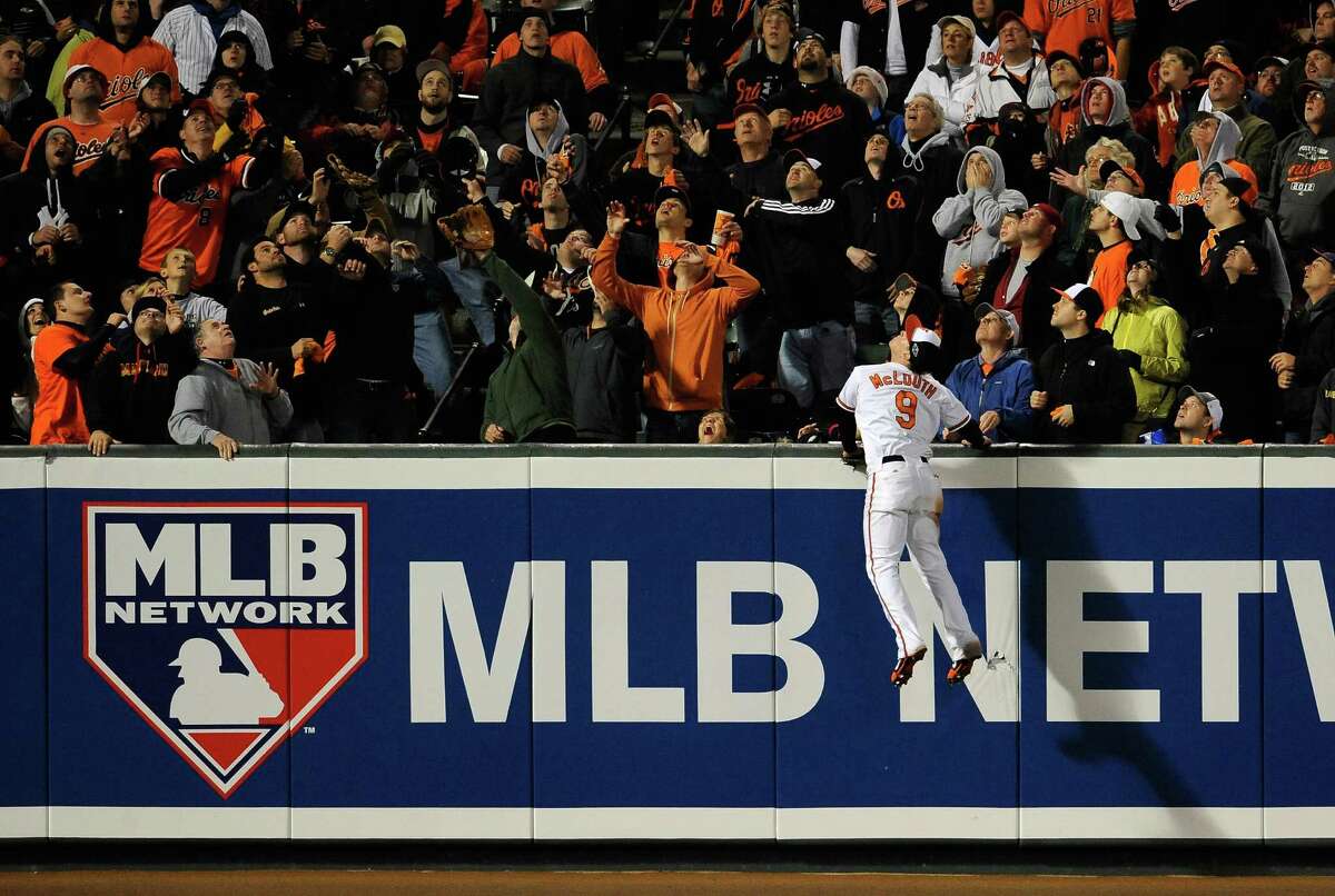 BALTIMORE, MD - OCTOBER 07: Nate McLouth #9 of the Baltimore Orioles climbs the wall as he can't make a play on a solo home run ball hit by Russell Martin #55 of the New York Yankees in the top of the ninth inning during Game One of the American League Division Series at Oriole Park at Camden Yards on October 7, 2012 in Baltimore, Maryland.