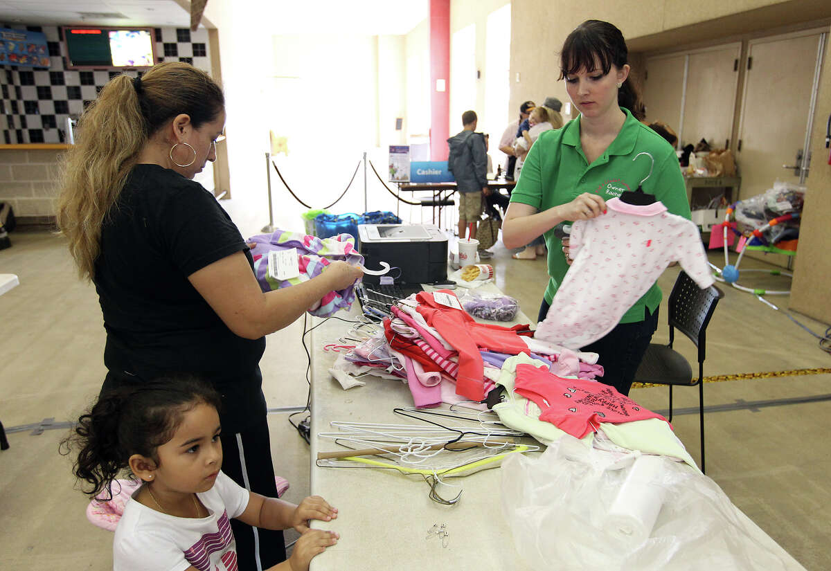 Kid's Closet Connection franchisee Rachel Brown (right) checks out a customer during a recent sale at Retama Park on Saturday, Sept. 29, 2012. The business sells children's items and clothing on consignment. They plan on running a sale twice a year which features items geared for children.