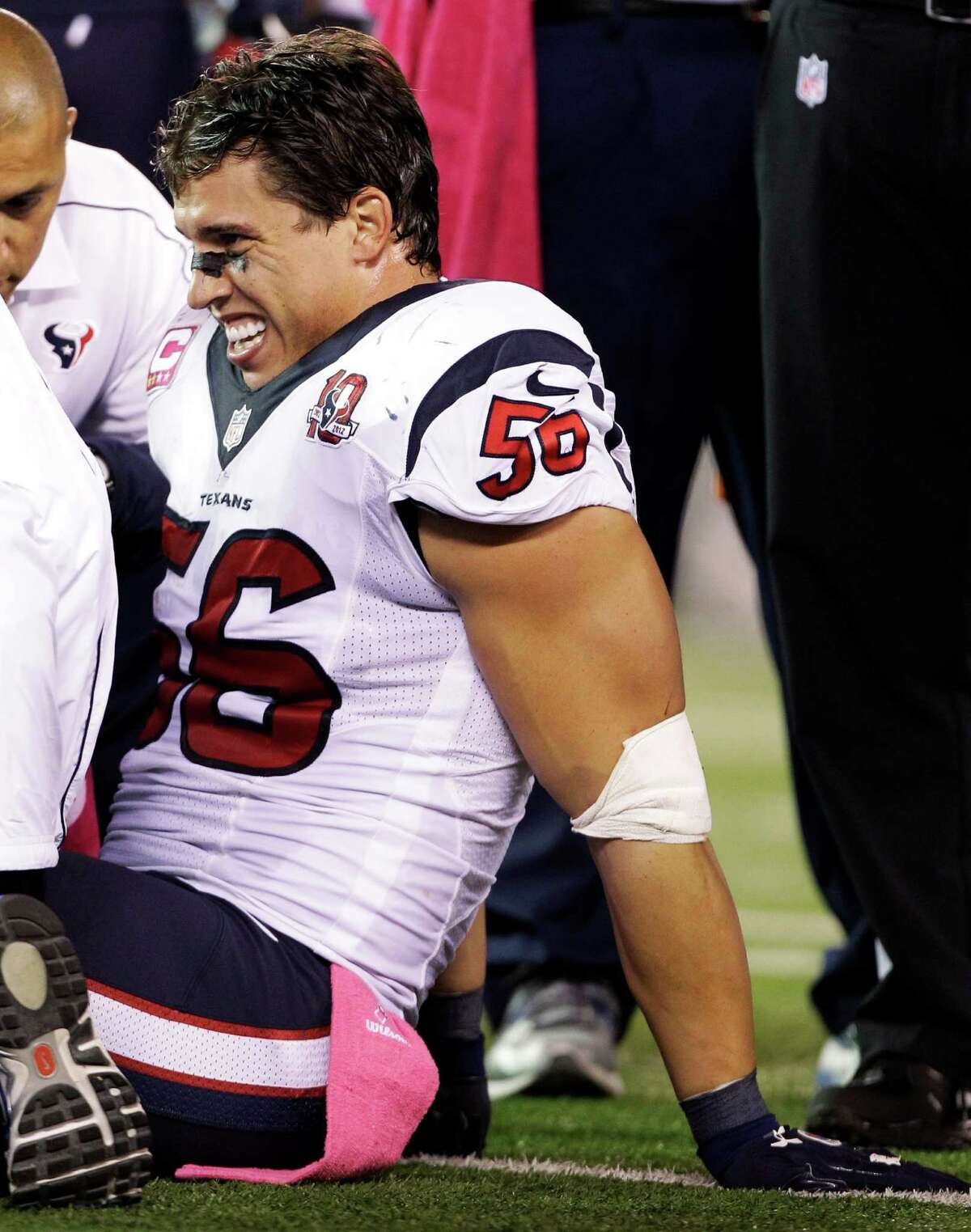 Trainers work on Houston Texans inside linebacker Brian Cushing (56) during the first half of an NFL football game against the New York Jets, Monday, Oct. 8, 2012, in East Rutherford, N.J. Cushing left the game in the second quarter with a left knee injury. (AP Photo/Kathy Willens)