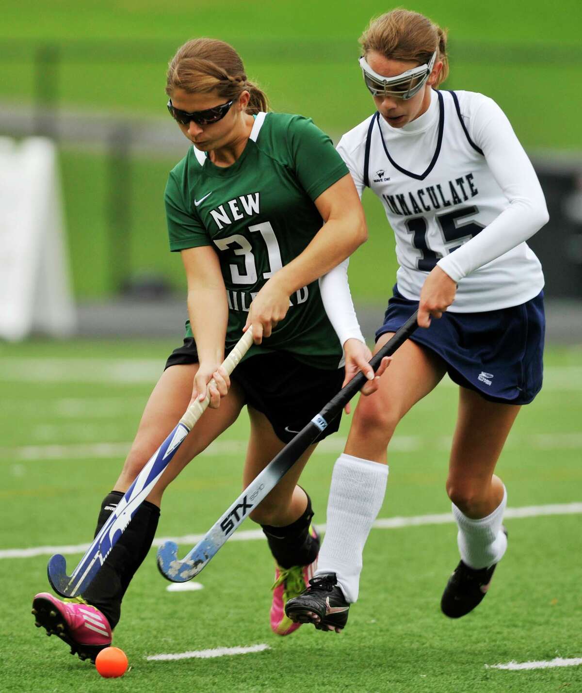 New Milford's Meghan Lacey fends off Immaculate's Katherine Archer during their game at Immaculate High School in Danbury on Tuesday, Oct. 9, 2012. New Milford won, 4-0.