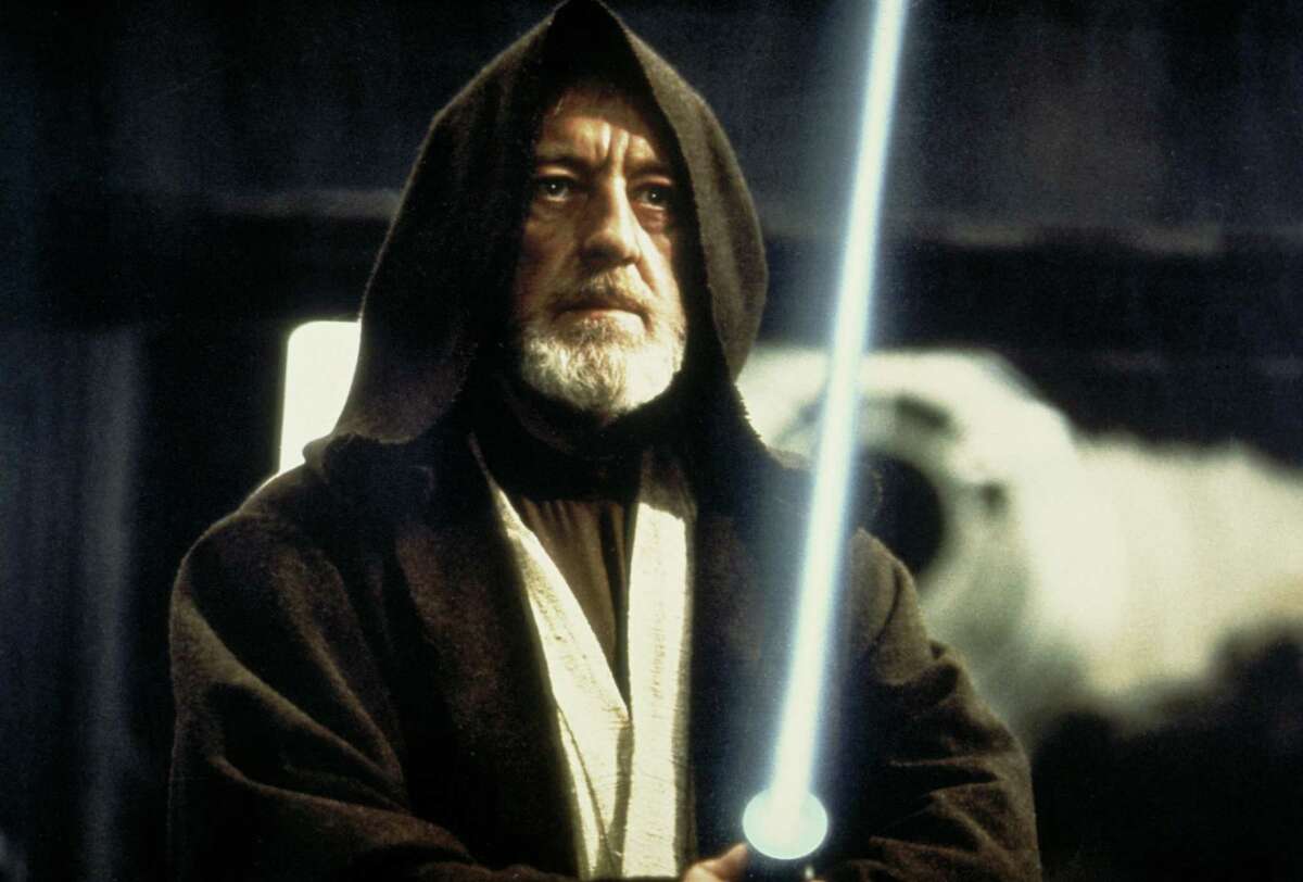 Ben (Obi-Wan) Kenobi (Alec Guinness) holds his lightsaber on the Death Star battle station in a scene from the film "Star Wars."