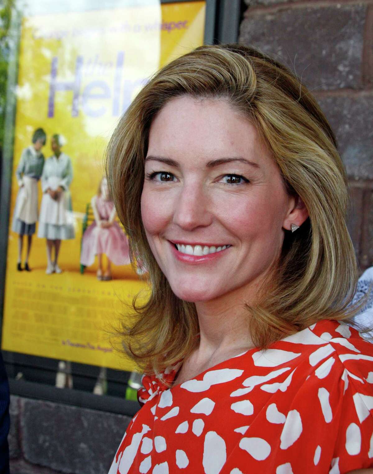 Author Kathryn Stockett poses by a poster for the movie made from her book prior to a benefit screening of "The Help" in Madison, Miss., Saturday, July 30, 2011. The film is based on the New York Times best-selling book by Stockett about the lives of three women in the 1960s Mississippi. (AP Photo/Rogelio V. Solis)
