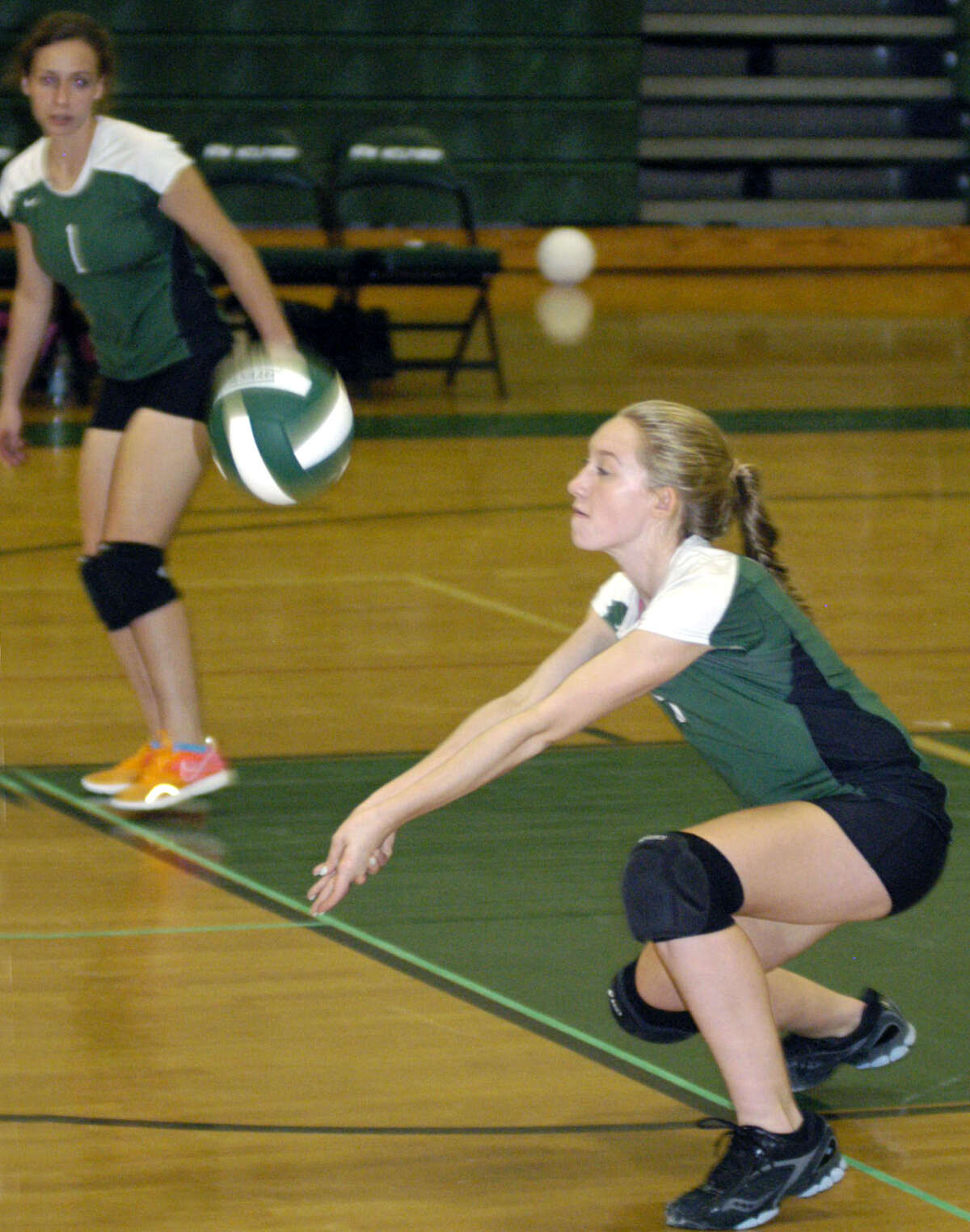 The Green Wave's Stephanie Fleet digs one out as teammate Juliana Fusco looks on during New Milford High School volleyball's victory over visiting Notre Dame of Fairfield, Oct. 5, 2012
