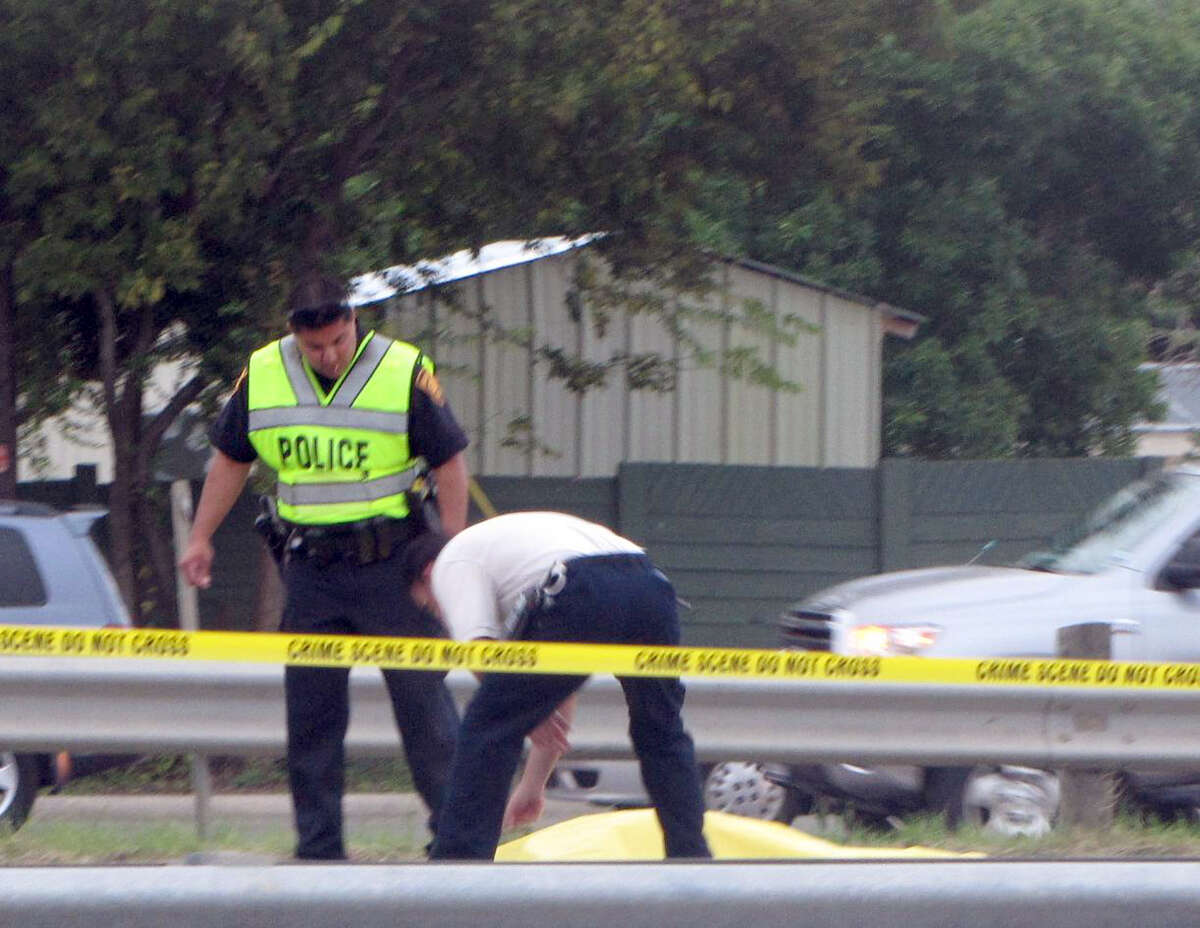 Police examine the site where a woman was killed while trying to cross Highway 90 at Military Drive on Thursday, Oct. 11, 2012.