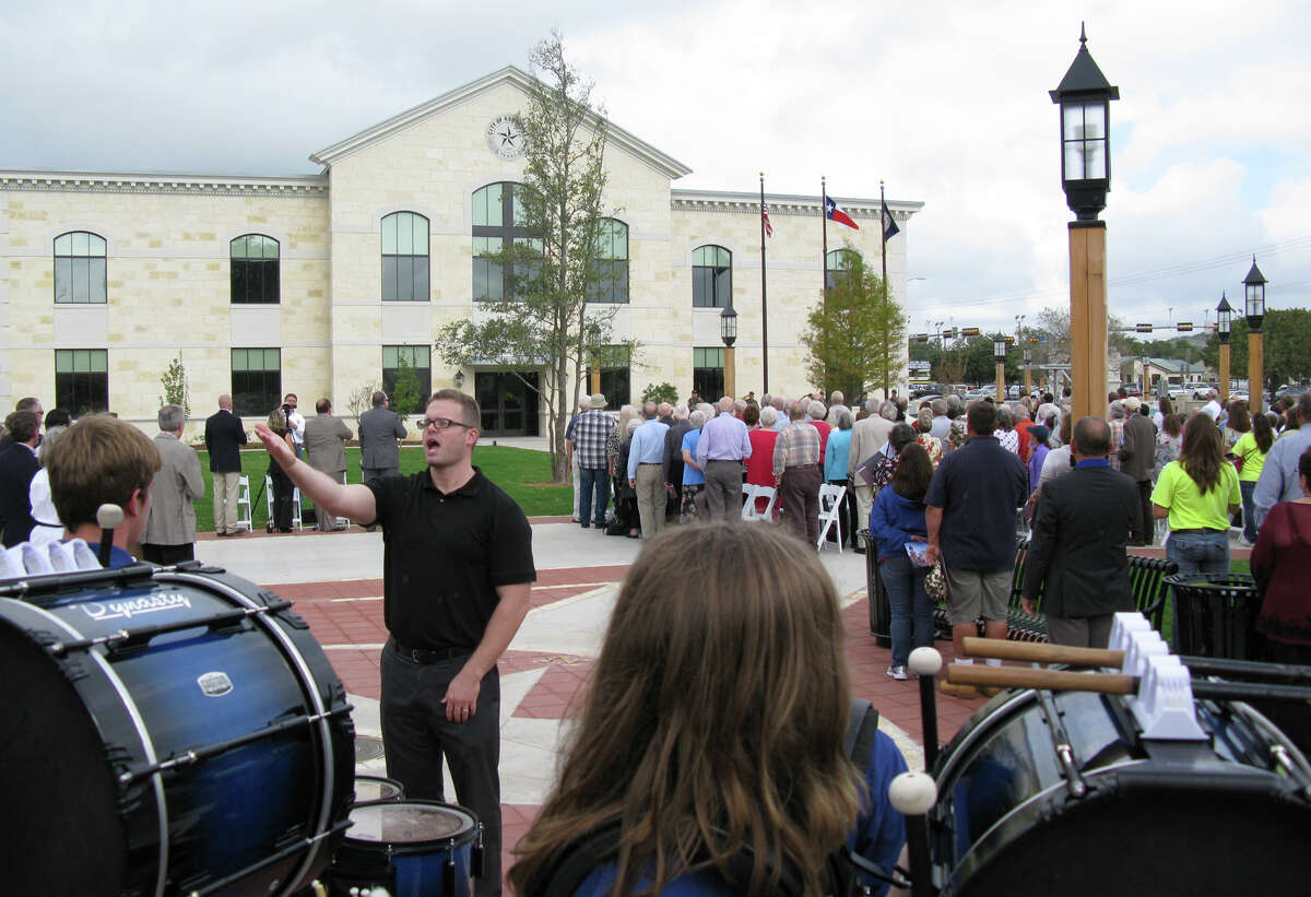 Jeff Thames(center) leads the Tivy High School camerata in the Star Spangled Banner at Thursday's dedication ceremony for the new Kerrville City Hall (rear). Zeke MacCormack zeke@express-news.net