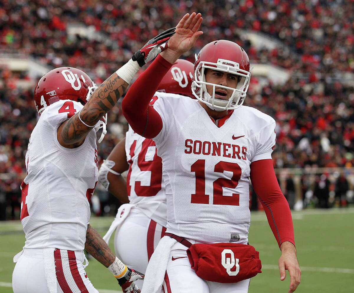 Oklahoma's Landry Jones (12) and Kenny Stills (4) celebrate after Oklahoma scored a touchdown against Texas Tech during an NCAA college football game in Lubbock, Saturday, Oct. 6, 2012.