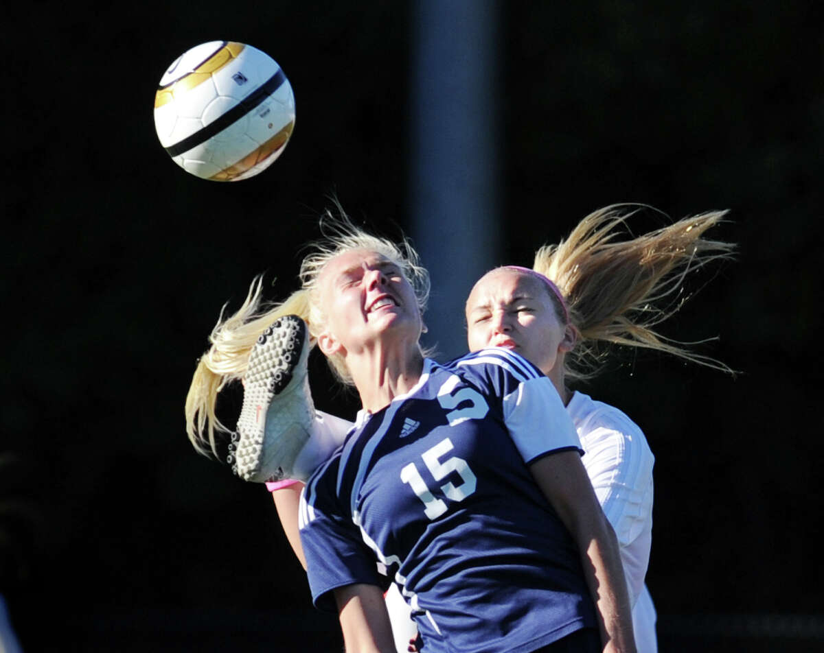 At left, Ryan Kirshner # 15 of Staples goes for the ball while nearing taking the foot of Emily Johnson of Greenwich to her head during the first half of the girls high school soccer match between Greenwich High School and Staples High School at Greenwich, Thursday, Oct. 11, 2012.