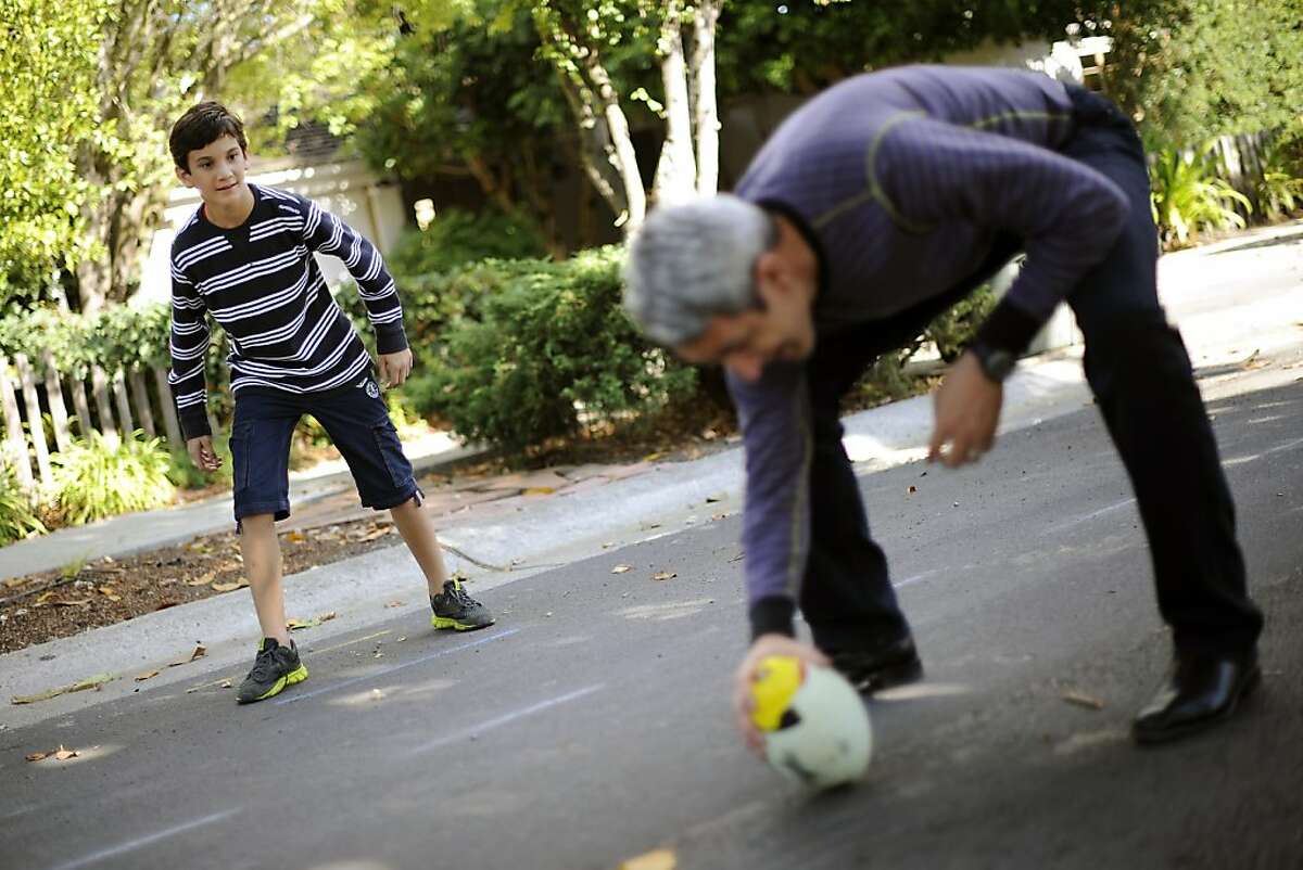 Colman Chadmon (L) plays football with his dad, Jaimy Chadmon, and his brother Aidan in front of their home on Tuesday, October 10th, 2012. Colman has been asked to leave his middle school in Palo Alto, CA because he has the genetic markers for cystic fibrosis and the school doesn't want him near another student who is already there with CF.