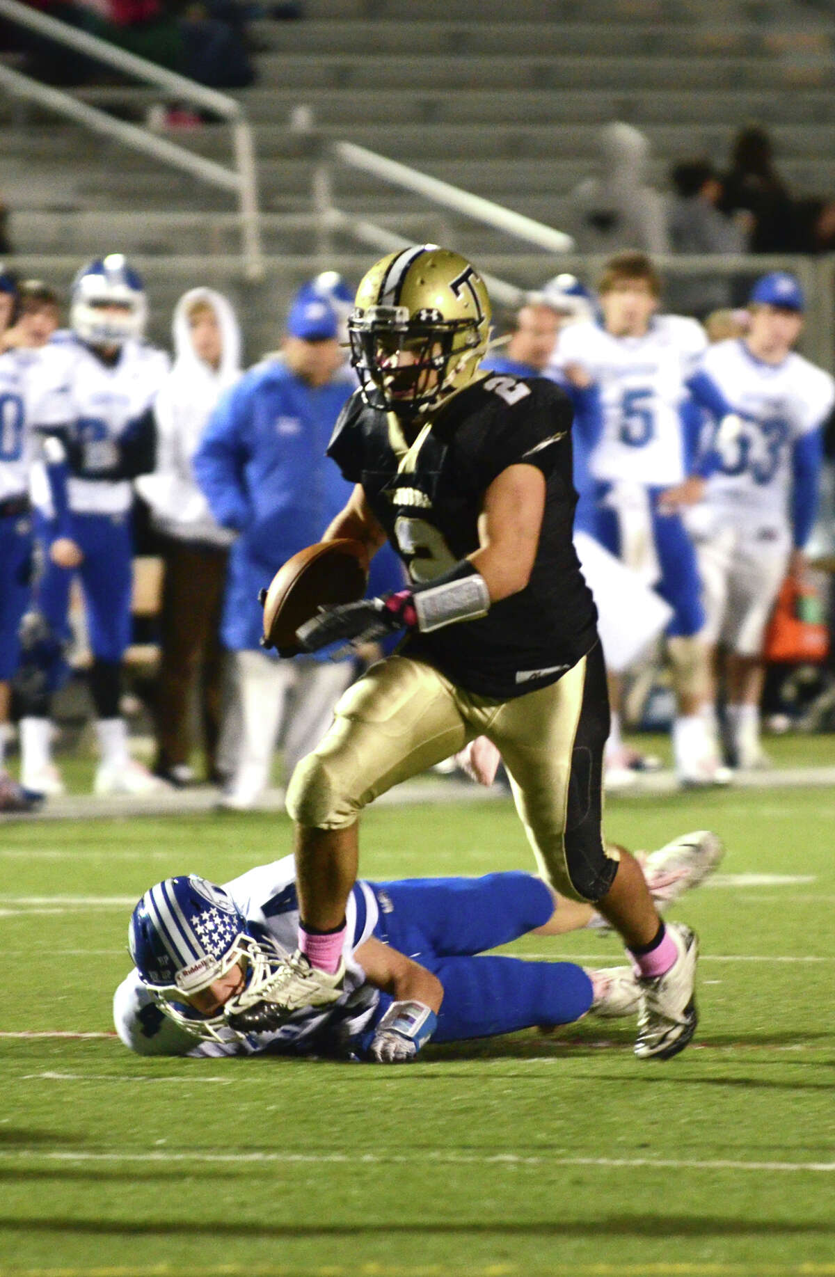 Trumbull's Ryan Pearson (2) carries the ball, stepping over Darien defender Jackson Whiting (4), during the football game against Darien at Trumbull High School on Friday, Oct. 12, 2012.