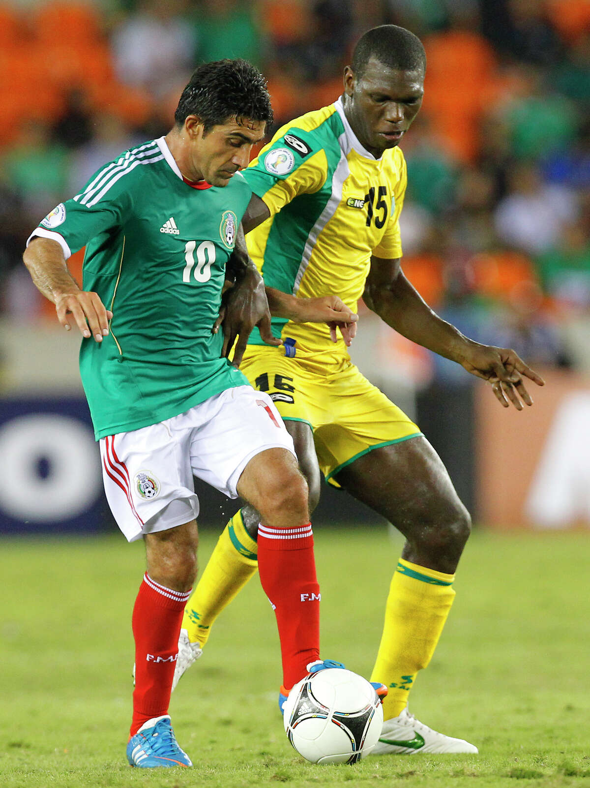 Mexico's Antonio Matias left, takes possession from a Guyana defender during the second half of their FIFA World Cup qualifying match at BBVA Compass Stadium Friday, Oct. 12, 2012, in Houston. Mexico won 5-0.