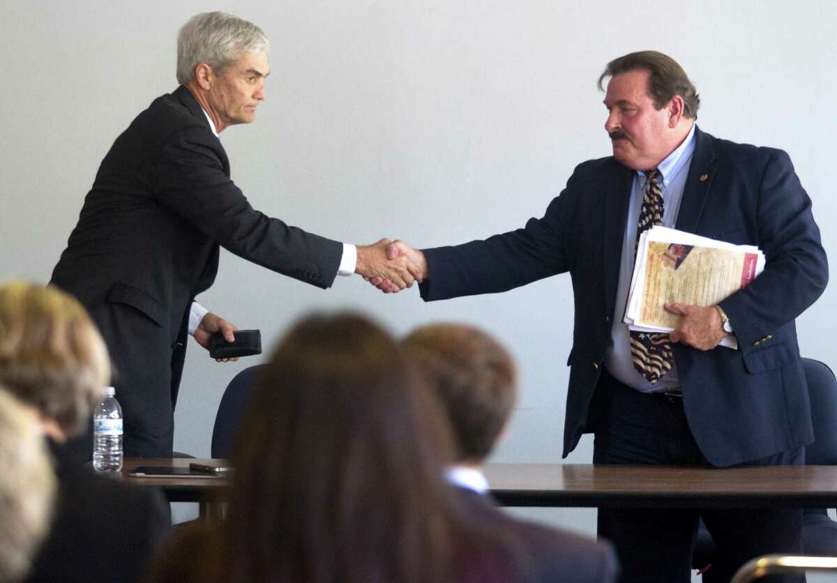Harris County District Attorney candidates Mike Anderson, left and Lloyd Oliver shake hands after speaking with the Harris County Domestic Violence Coordinating Council on Thursday.