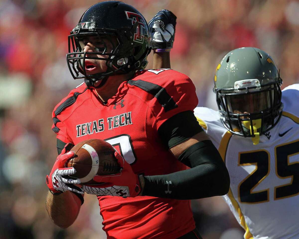 Texas Tech's Jace Amaro catches a pass for a touchdown ahead of West Virginia's Darwin Cook during an NCAA college football game in Lubbock, Texas, Saturday, Oct. 13, 2012. (AP Photo/Lubbock Avalanche-Journal, Stephen Spillman) LOCAL TV OUT