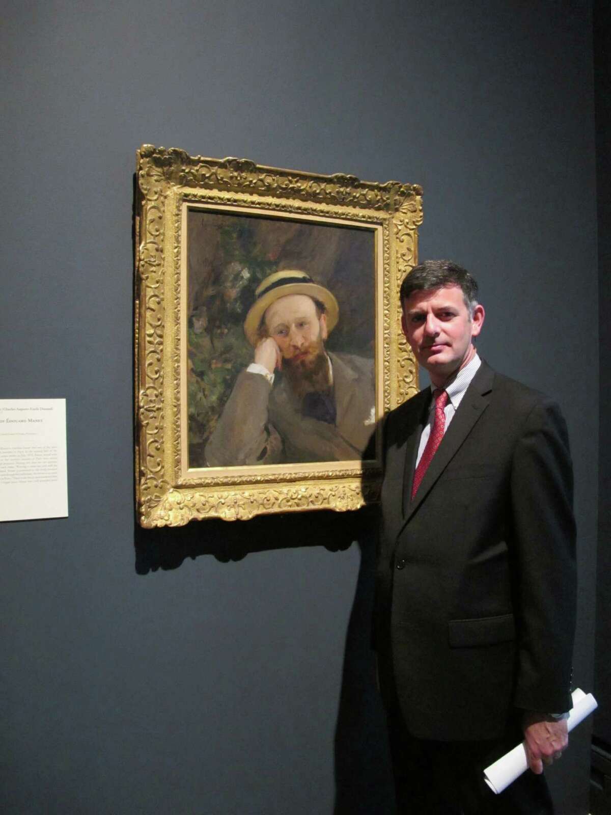 Brian Kennedy, director of the Toledo Museum of Art, poses in front of a portrait of French Impressionist Edouard Manet, Wednesday, Oct. 3, 2012, in Toledo, Ohio. An exhibition of Manet's works opened this month and runs through the end of the year before moving onto the Royal Academy of Arts in London. (AP Photo/John Seewer)