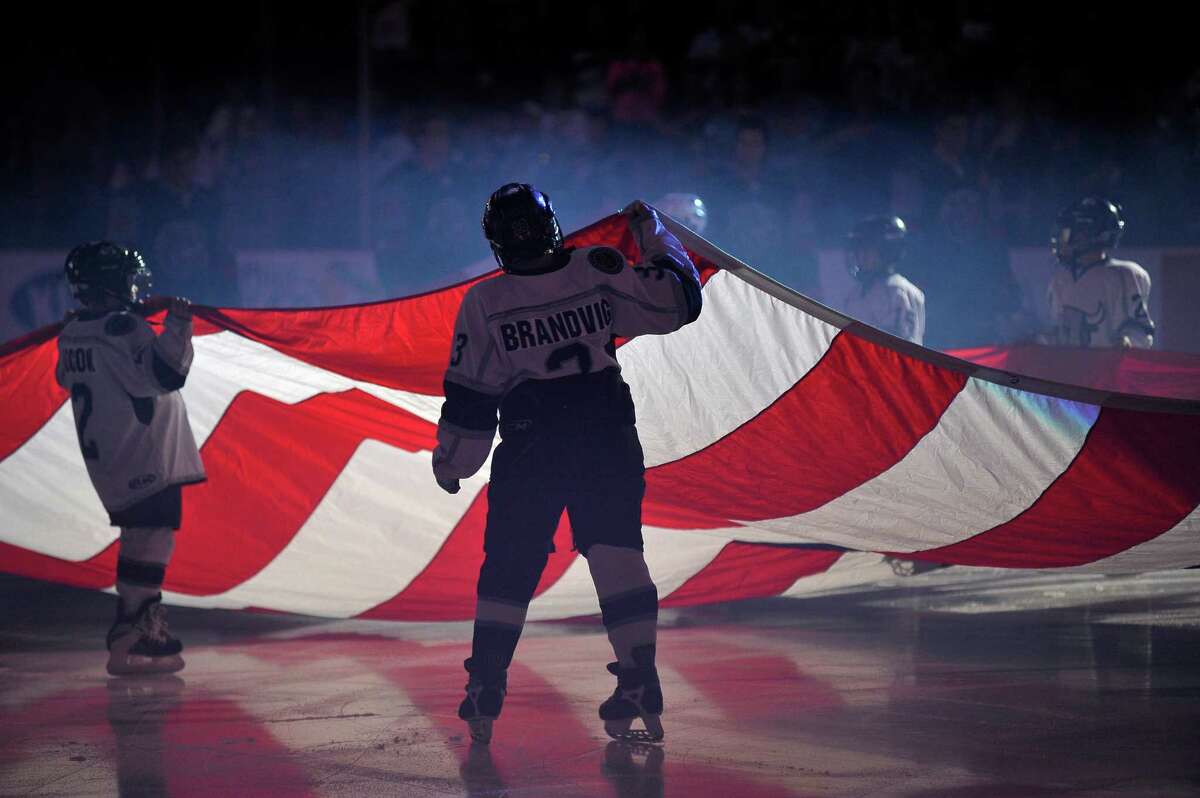 Junior Rampage hockey players hold an American flag during the national anthem before during an AHL hockey game between the San Antonio Rampage and the Houston Aeros, Sunday, Oct. 14, 2012, in San Antonio. San Antonio won 3-2. (Darren Abate/pressphotointl.com)