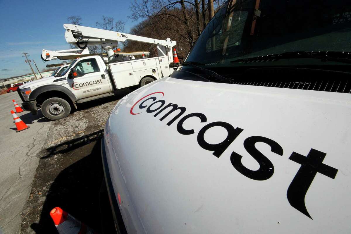 FILE - In this Feb. 15, 2011 file photo, Comcast logos are displayed on installation trucks in Pittsburgh.  (AP Photo/Gene J. Puskar, file)