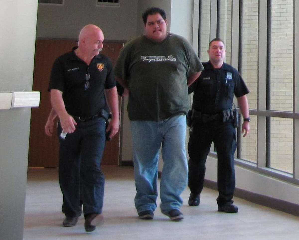 Police escort Bernardo Crisanto, 25, as he is transported to the county magistrate’s office on Thursday, October 18, 2012. Crisanto was charged with murder in connection with the beating death of Juan Romero, 41.